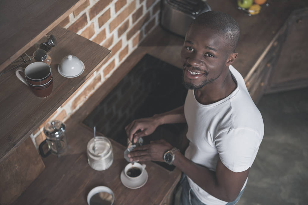 朝 自宅で朝食のためのコーヒーを準備するアフリカ系アメリカ人 ロイヤリティフリー写真 画像素材