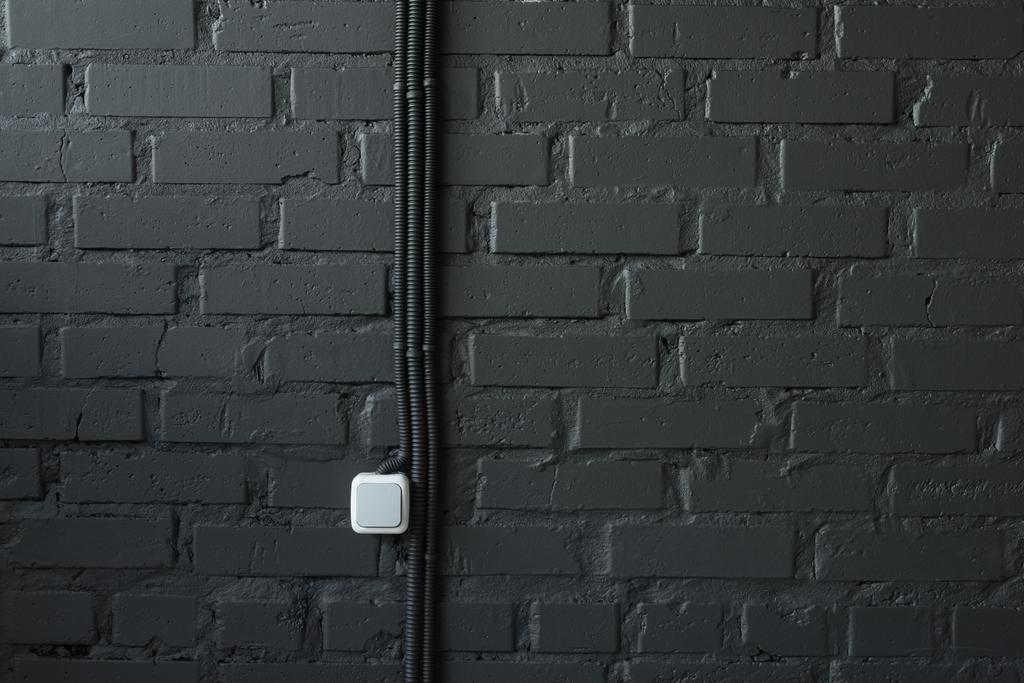 電気スイッチと黒レンガの線壁の背景 ロイヤリティフリー写真 画像素材