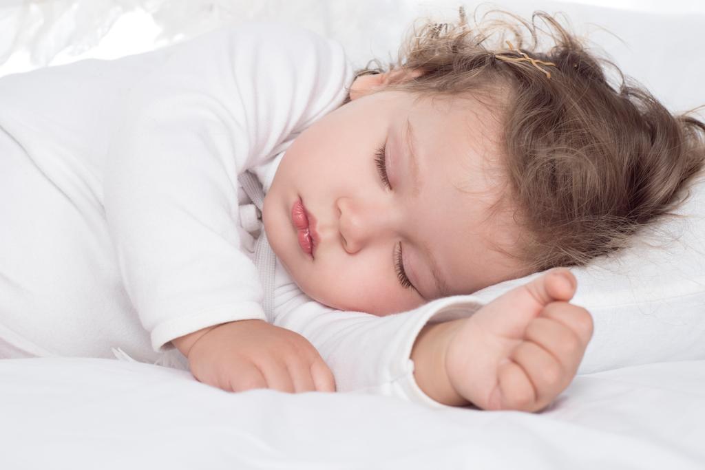 ベッドで眠っているかわいい赤ちゃん女の子 ロイヤリティフリー写真 画像素材