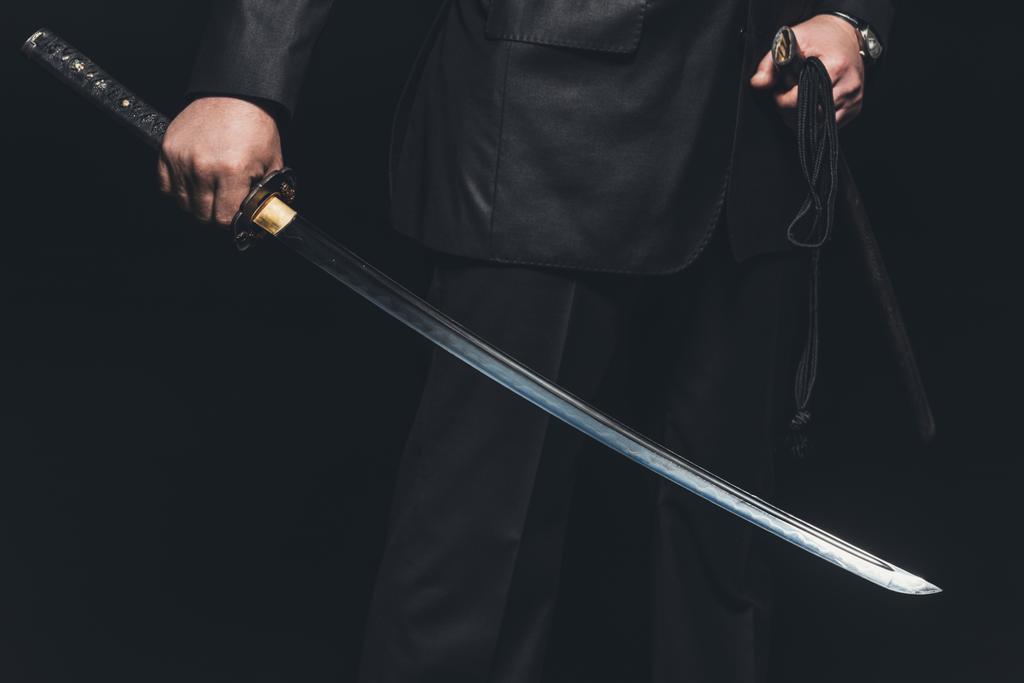 黒い背景に刀を持つ男のショットをトリミング ロイヤリティフリー写真 画像素材
