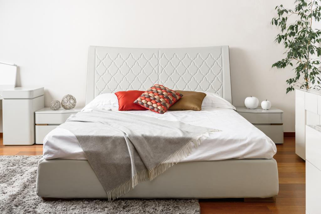 白いベッドの上色枕とモダンなライト ベッドルームのインテリア ロイヤリティフリー写真 画像素材