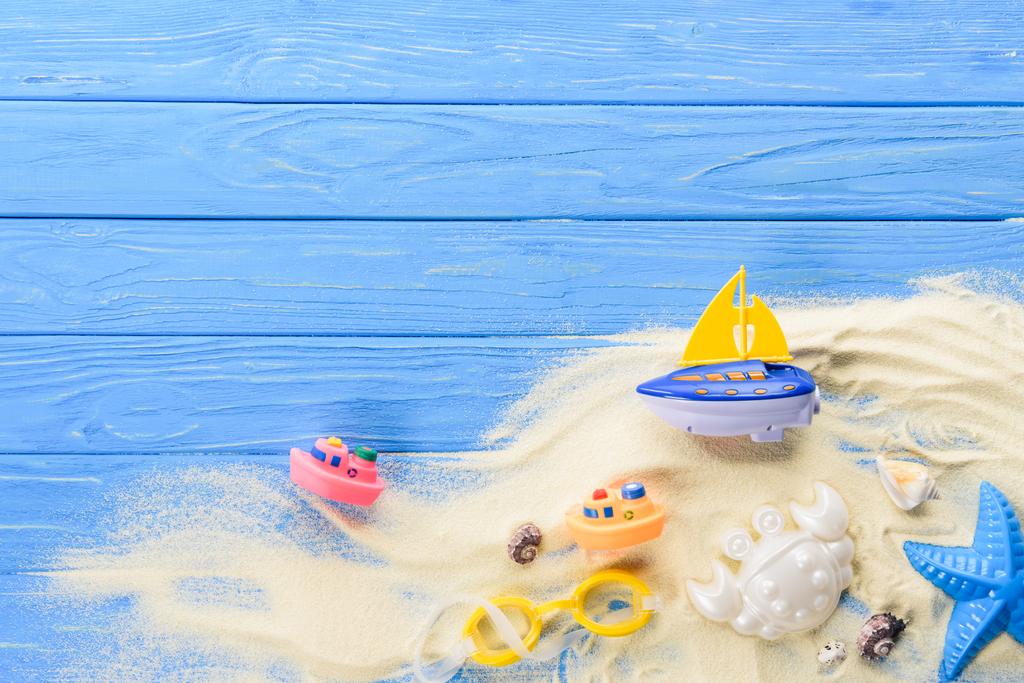 青い木製の背景の砂のビーチおもちゃ ロイヤリティフリー写真 画像素材