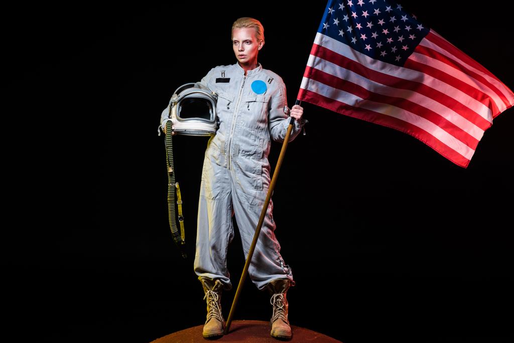 火星のヘルメットとアメリカの国旗を保持している宇宙服で行わ ロイヤリティフリー写真 画像素材