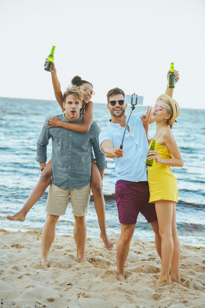 海で Selfie を取ってビールと人種の若い友達 ロイヤリティフリー写真 画像素材
