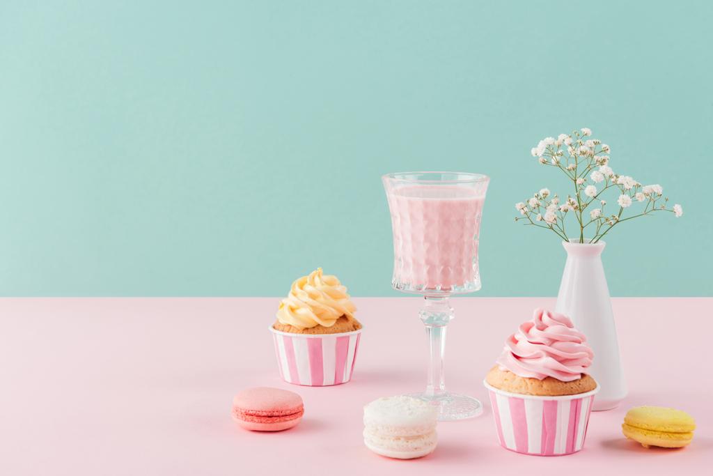 カップケーキ ミルクセーキと花と誕生の背景のマカロン ロイヤリティフリー写真 画像素材