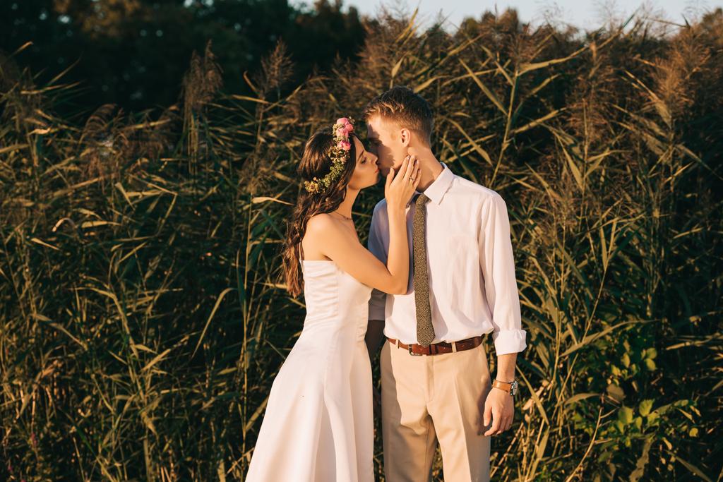 美しいエレガントな若いロマンチックな結婚式のカップルが公園でキス ロイヤリティフリー写真 画像素材