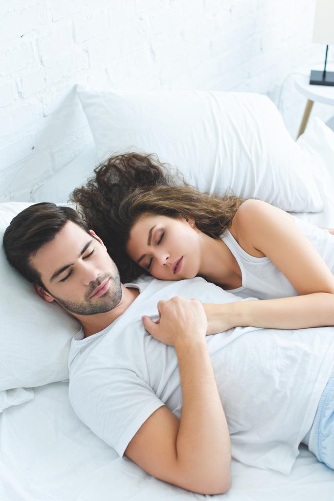 ベッドで一緒に寝ている間手を繋いでいるカップルのハイアングル ロイヤリティフリー写真 画像素材