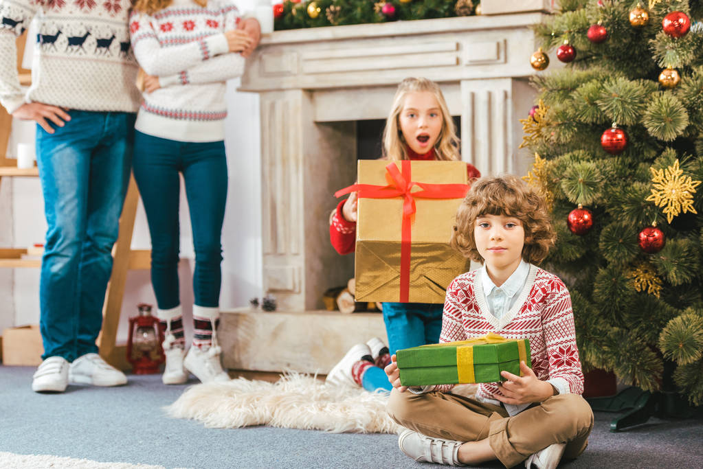 自宅のクリスマス プレゼントで子供たちの後ろに立って親のクロップ撮影 ロイヤリティフリー写真 画像素材