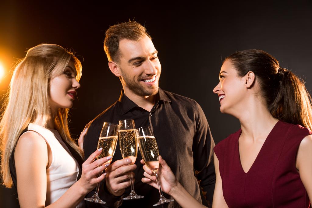 黒に黄金の光の下でシャンパン グラスに素晴らしく幸せな友人のグループ ロイヤリティフリー写真 画像素材