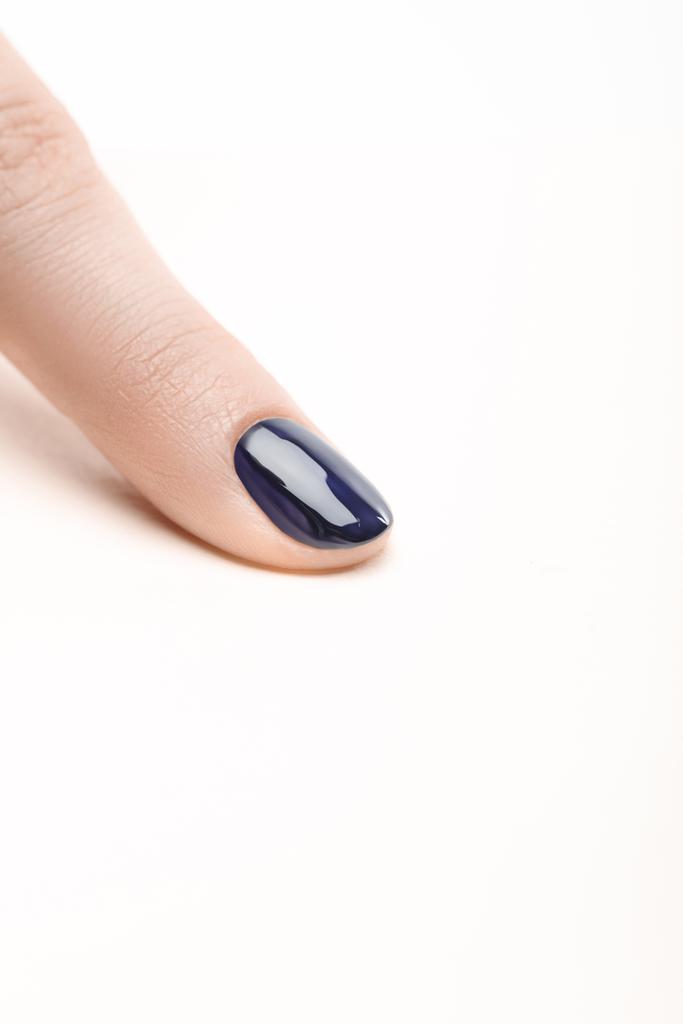 白い背景の光沢のあるネイビー ブルーのマニキュアを指の爪 ロイヤリティフリー写真 画像素材