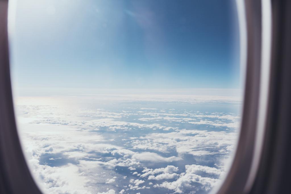 飛行機の窓から青い曇り空のビュー ロイヤリティフリー写真 画像素材