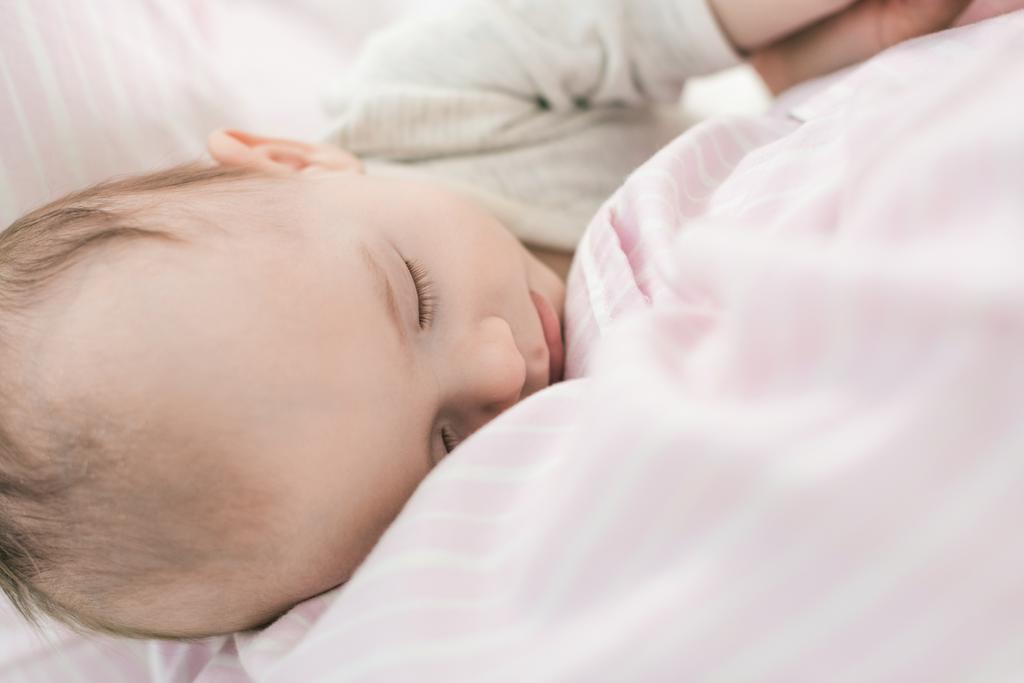 母親の手で眠っているかわいい赤ちゃんの部分的なビュー ロイヤリティフリー写真 画像素材