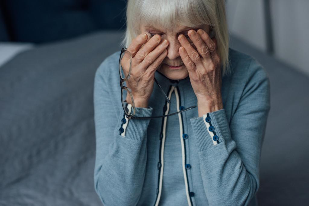 メガネと涙を拭くと 家で泣いている白髪の年配の女性を混乱させる ロイヤリティフリー写真 画像素材