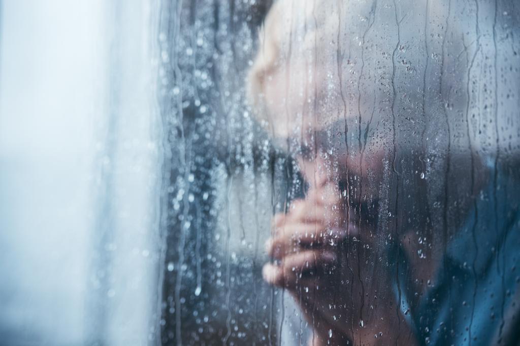 雨粒が窓から家に手を組んで悲しい大人の女性 ロイヤリティフリー写真 画像素材