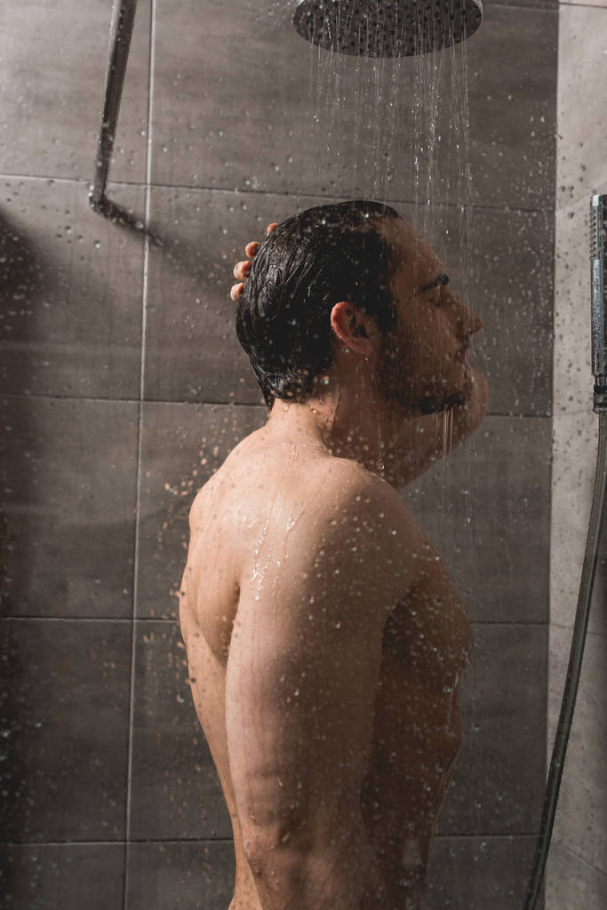 Handsome and naked man taking shower in cabin Free Stock Photo and Image