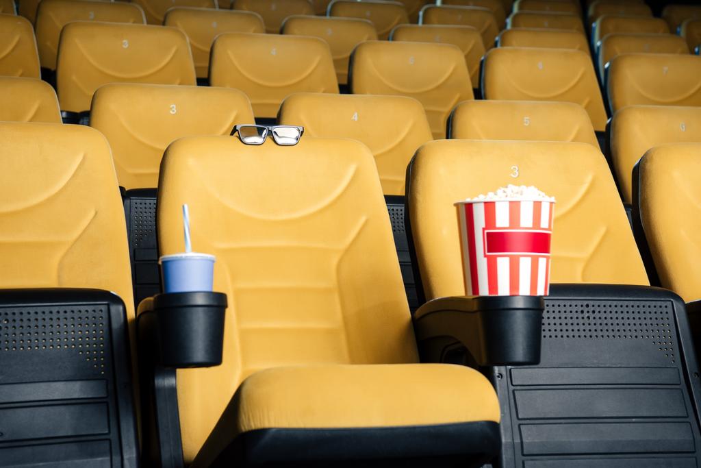 ソーダとカップ ホルダーと 3 D メガネでポップコーンの紙コップ オレンジ映画館座席 ロイヤリティフリー写真 画像素材