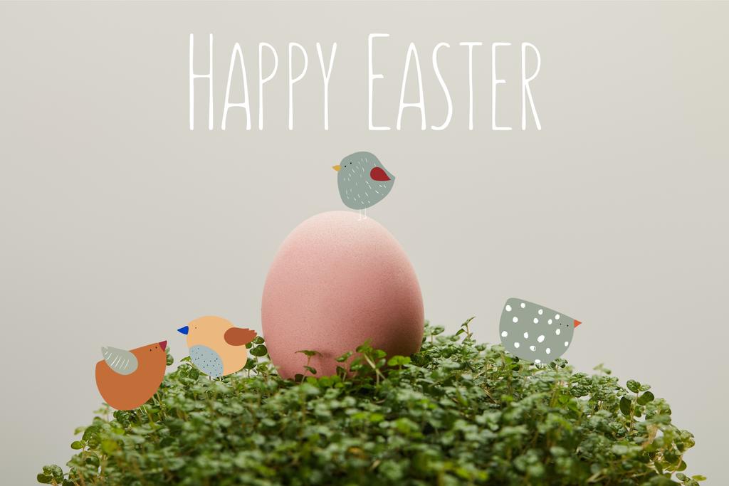緑の草の上にピンク色の鶏の卵が描かれ ハッピーイースターのレタリングと鳥のイラストがグレーの背景に ロイヤリティフリー写真 画像素材