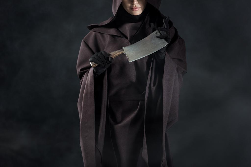 黒に包丁を持つ死の衣装の女性の部分的なビュー ロイヤリティフリー写真 画像素材