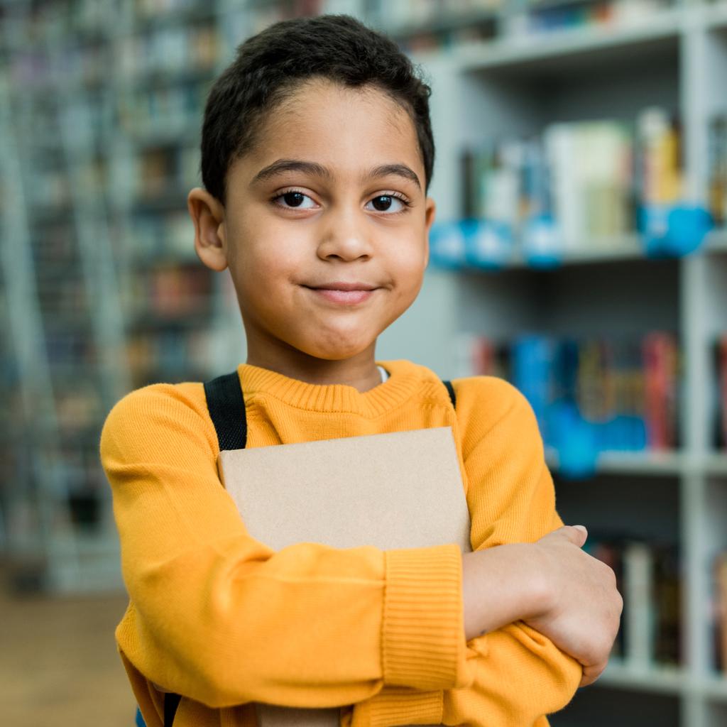 Download Cute African American Boy Smiling While Holding Book Free Stock Photo And Image