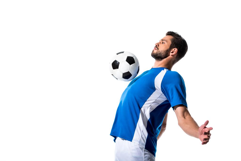 コピースペースで白に隔離されたボールでハンサムなサッカー選手のトレーニング ロイヤリティフリー写真 画像素材