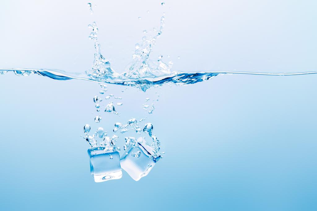 青い背景にスプラッシュ 気泡と氷の立方体と透明な水 ロイヤリティフリー写真 画像素材