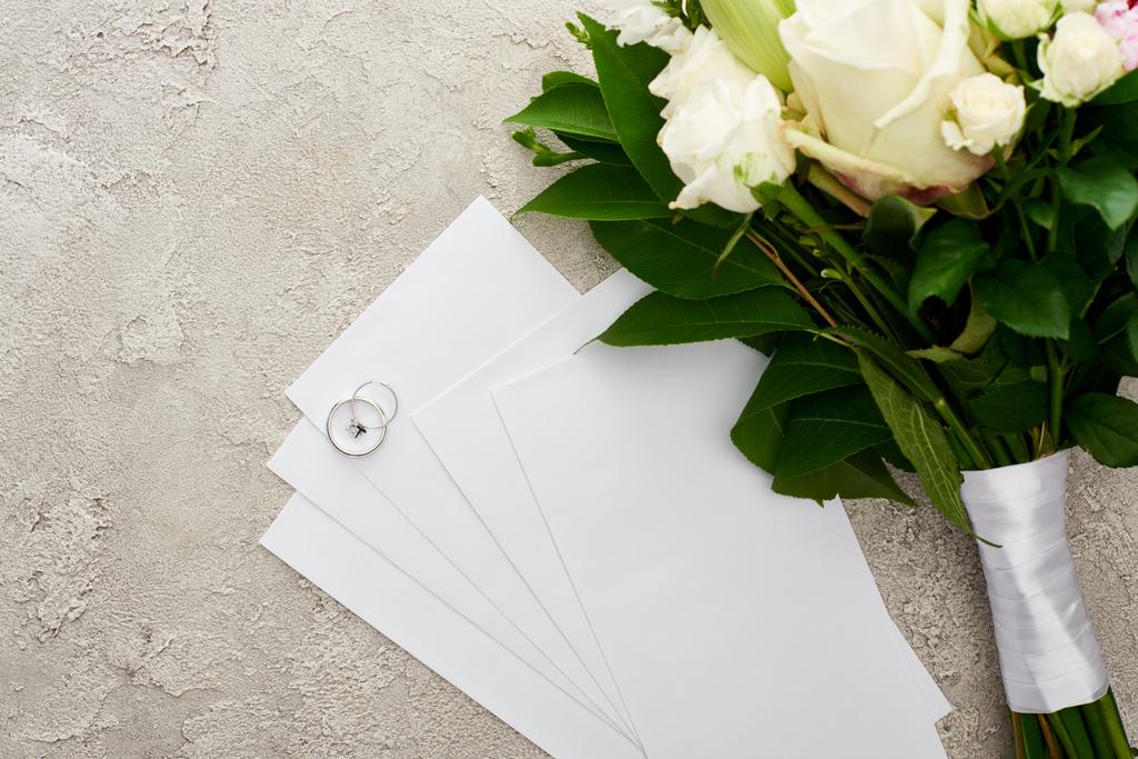 テクスチャ面の花束付近の招待状のシルバーリングの上のビュー ロイヤリティフリー写真 画像素材