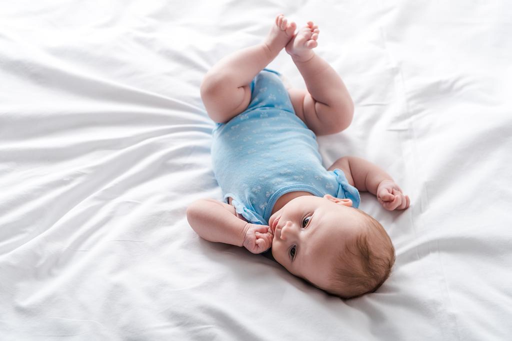 ベビールーマーの可愛い赤ちゃんが家のベッドに横になり ロイヤリティフリー写真 画像素材