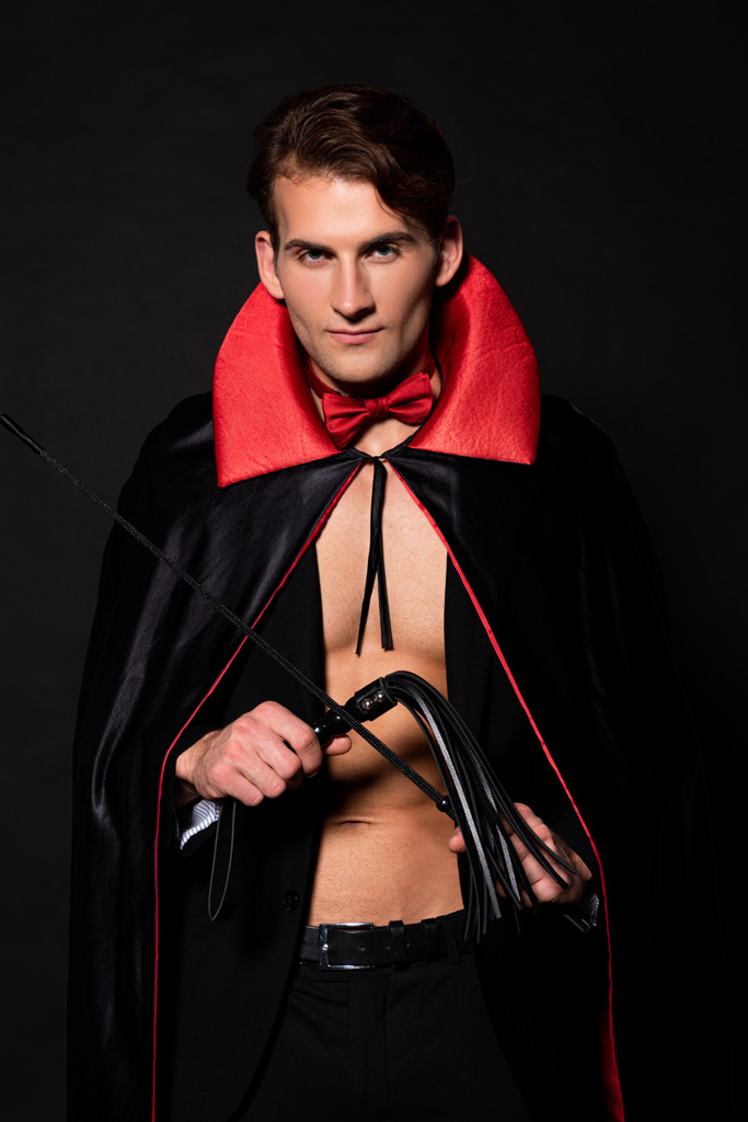 ハンサムな男で吸血鬼ハロウィンの衣装を保持フロッグ鞭隔離された黒 ロイヤリティフリー写真 画像素材