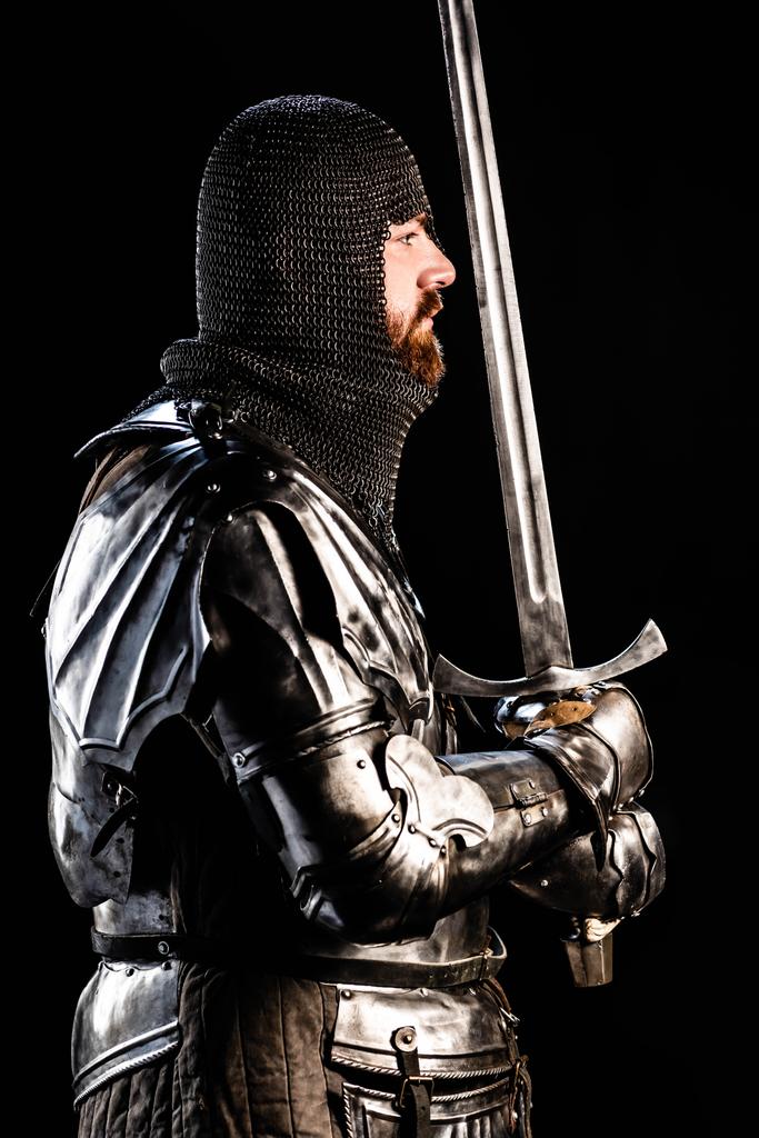 黒で隔絶された鎧を着たハンサムな騎士の側面図 ロイヤリティフリー写真 画像素材