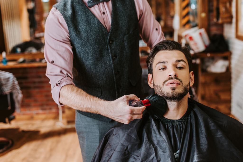 ひげそりの男の顔の近くに化粧ブラシを保持理髪店 ロイヤリティフリー写真 画像素材