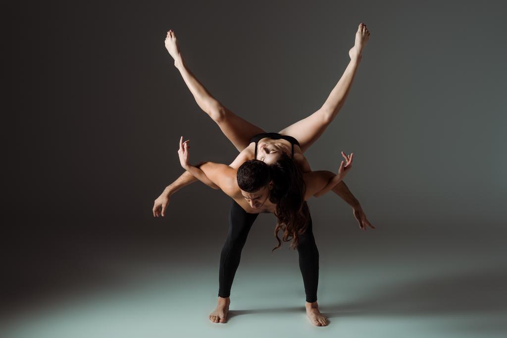 セクシーなダンサーがダークな背景でコンテンポラリーダンスを踊る ロイヤリティフリー写真 画像素材