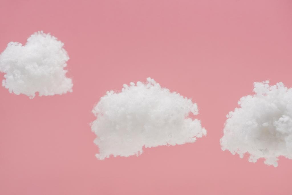 ピンクに隔離されたコットンウールで作られた白いふわふわの雲 ロイヤリティフリー写真 画像素材