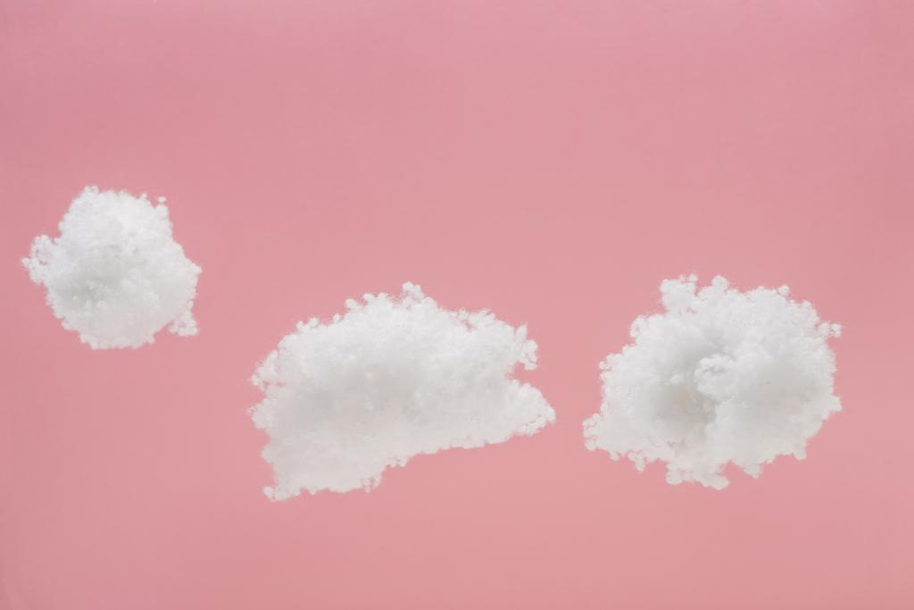 ピンクに隔離されたコットンウールで作られた白いふわふわの雲 ロイヤリティフリー写真 画像素材
