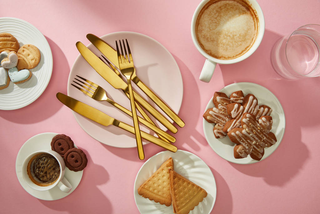 ピンク色の表面にコーヒーと水でグルメクッキーとビスケットのトップビュー ロイヤリティフリー写真 画像素材