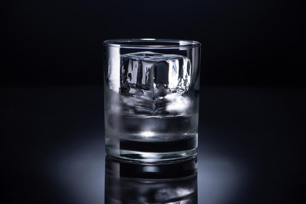 黒の背景に氷のキューブとウォッカの透明なガラス ロイヤリティフリー写真 画像素材