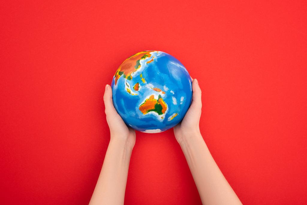 赤い背景に地球を持つ女性の作物のビュー 地球温暖化の概念 ロイヤリティフリー写真 画像素材