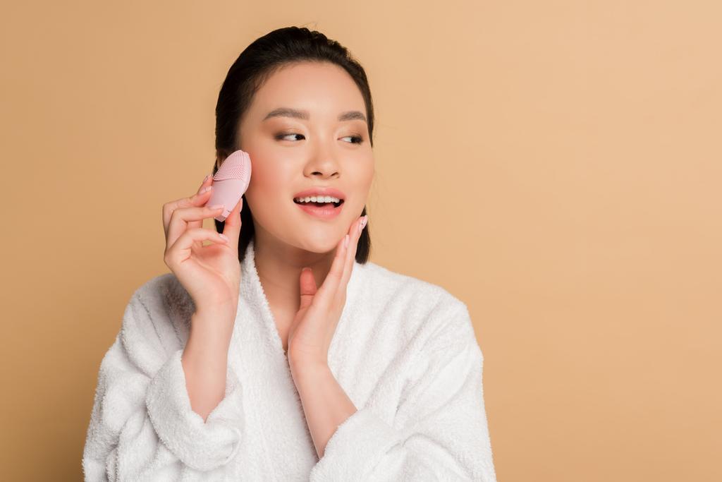 ベージュ地に洗顔ブラシで美人アジア人女性 ロイヤリティフリー写真 画像素材