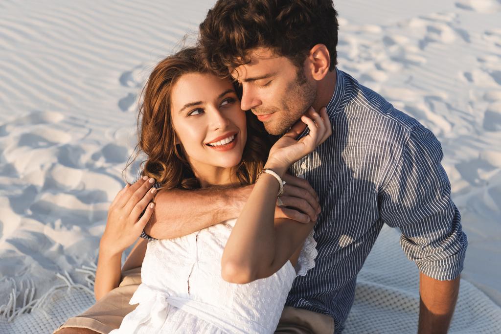 若いカップルがビーチで抱き合って笑っています ロイヤリティフリー写真 画像素材