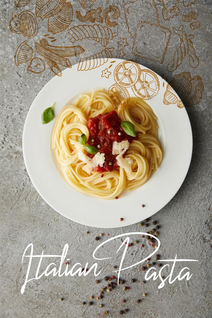 イタリアのパスタイラストが入った灰色の食感の表面にトマトソースをかけたおいしいスパゲティのトップビュー ロイヤリティフリー写真 画像素材
