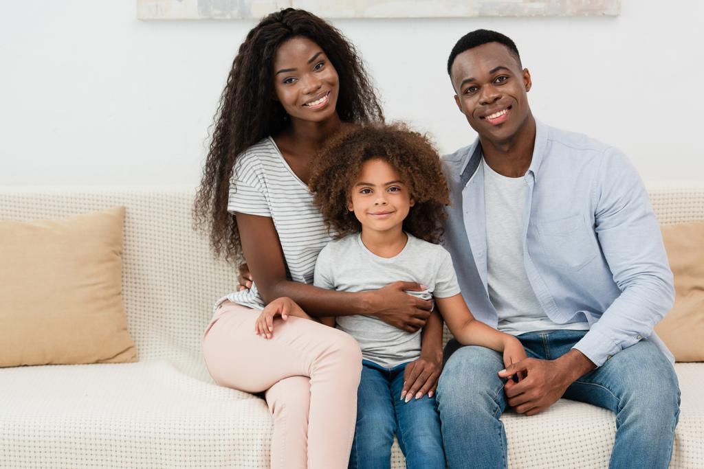 Afrikanisch Amerikanische Familie Blickt In Die Kamera Und Sitzt Auf Dem Sofa Im Wohnzimmer Lizenzfreies Foto Und Stockbild