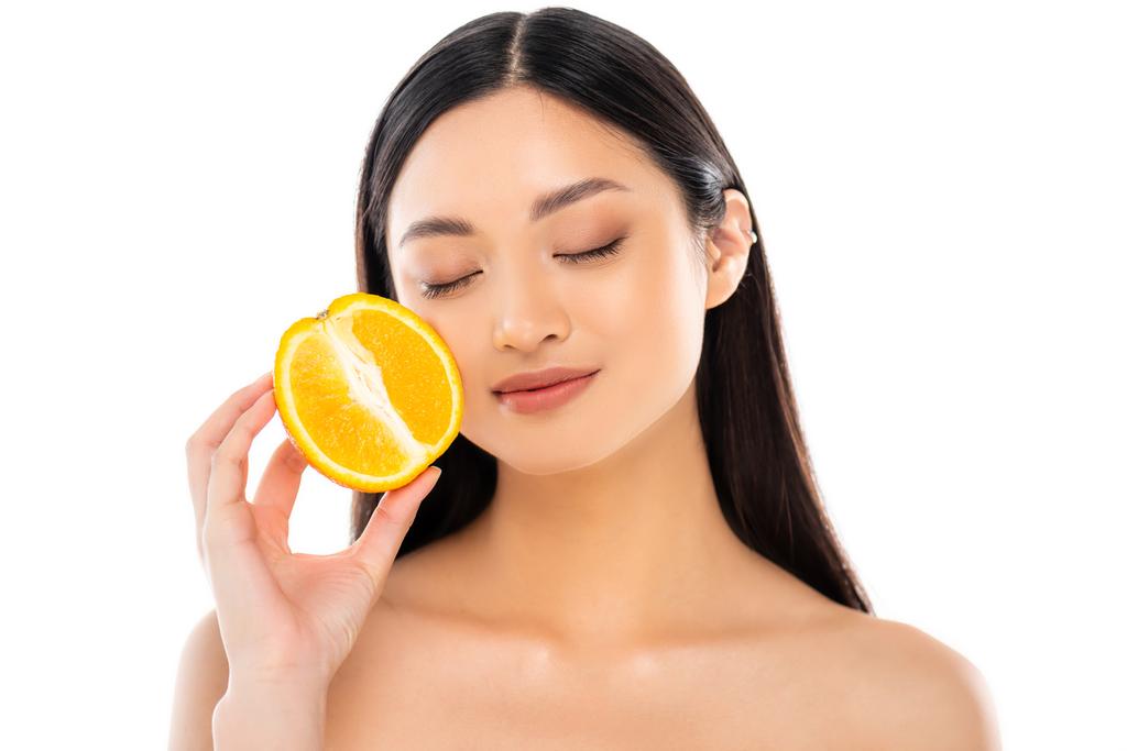 Young asian woman with closed eyes holding half of juicy orange near face  isolated on white Free Stock Photo and Image