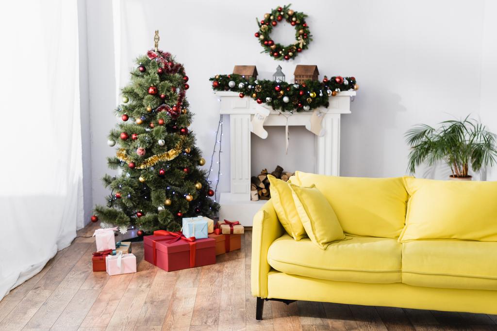 クリスマスツリーの下に飾られたモダンなリビングルームでプレゼントを包んだ ロイヤリティフリー写真 画像素材