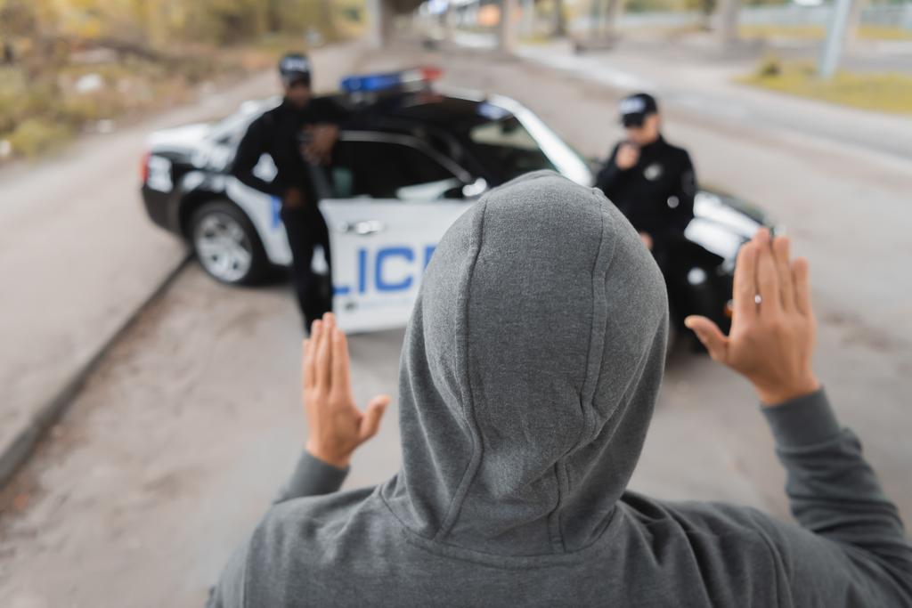 背景に多文化警察官が手を見せているフード犯罪者の裏側 ロイヤリティフリー写真 画像素材