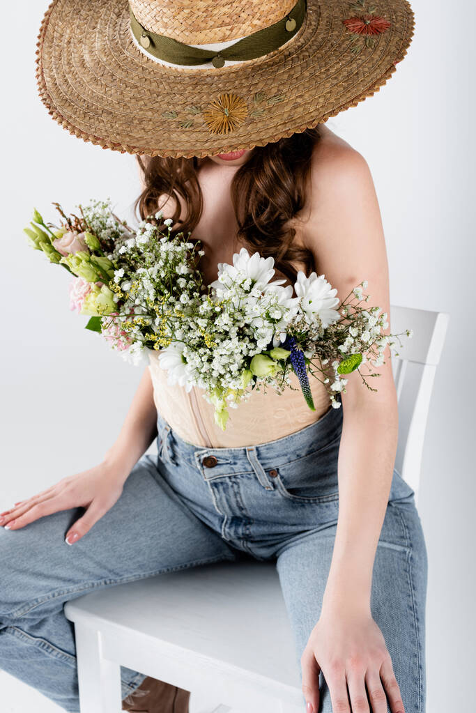 麦藁帽子カバー顔の女性で花でブラウスに隔離された灰色 ロイヤリティフリー写真 画像素材