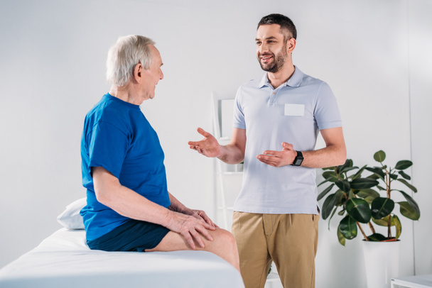 Side View Of Rehabilitation Therapist Doing Massage To Senior Man On