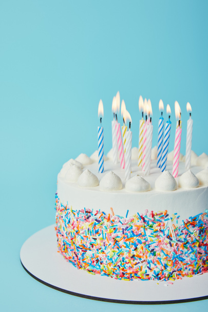 青の背景に照明キャンドルで誕生日ケーキ ロイヤリティフリー写真 画像素材