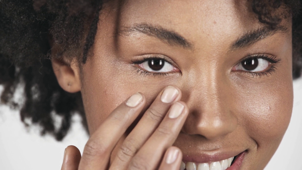 カメラ目線と白で隔離の顔に触れる美しいブルネットのアフリカ系アメリカ人少女のクローズ アップ ストック動画映像