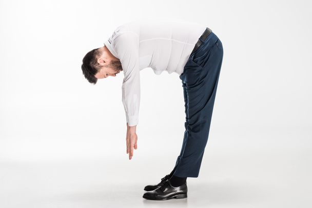 overweight man in tight formal wear bending over and stretching on white - ...