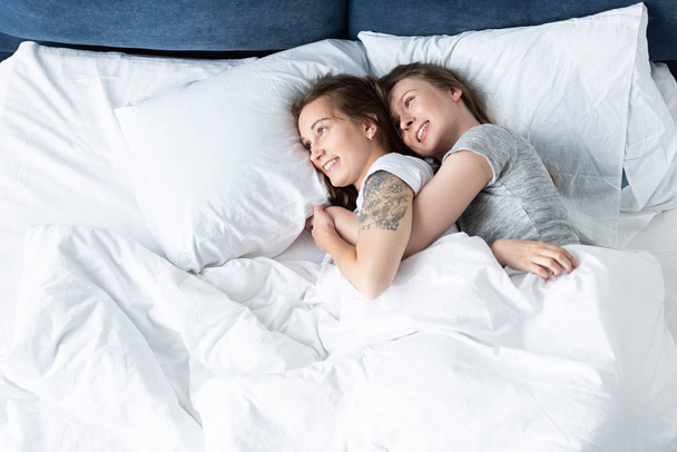 Zwei schöne Lesben genießen einen Tag im Bett