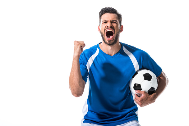 ボールと握りしめ手で興奮したサッカー選手は白に孤立した叫び声 ロイヤリティフリー写真 画像素材